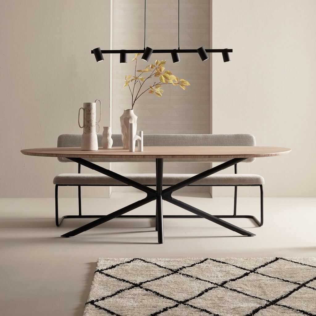 Ein schöner tisch in eiche hell mit kreuzbeinen und deko auf dem tisch